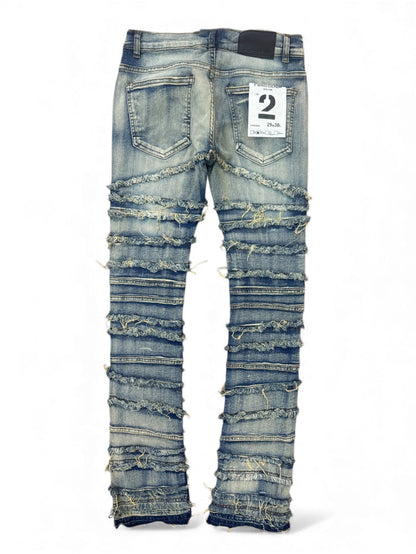 Light wash FWRD distressed frayed stacked denim jeans with a relaxed fit and frayed hem, showcased on a model.