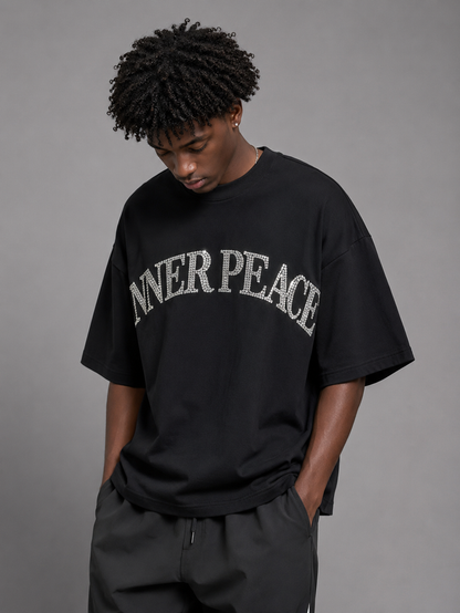 Black Inner Peace 'Peace Everywhere' oversized rhinestone T-shirt with bold peace symbol design on the front.