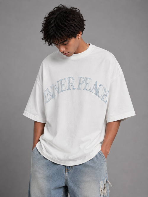 White Inner Peace 'Peace Everywhere' oversized rhinestone T-shirt with bold text design on front, casual fit, and soft fabric.