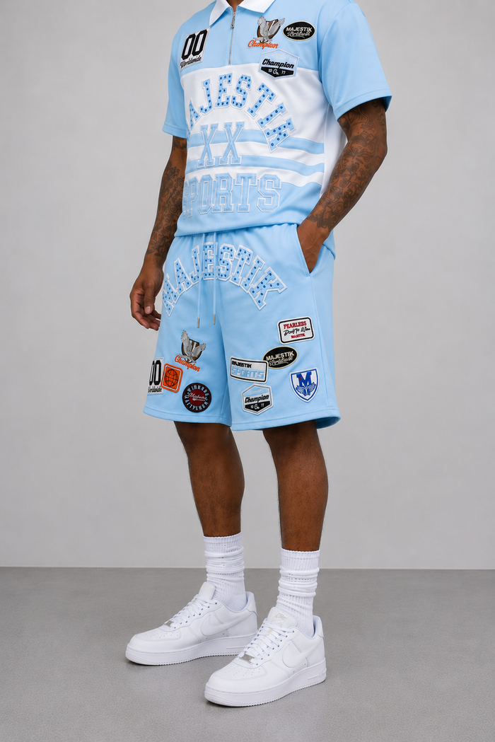 Light blue Majestik Champion rhinestone rugby patched shorts with decorative patches and stylish design.