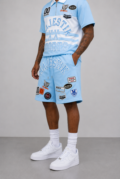 Light blue Majestik Champion rhinestone rugby patched shorts with decorative patches and stylish design.