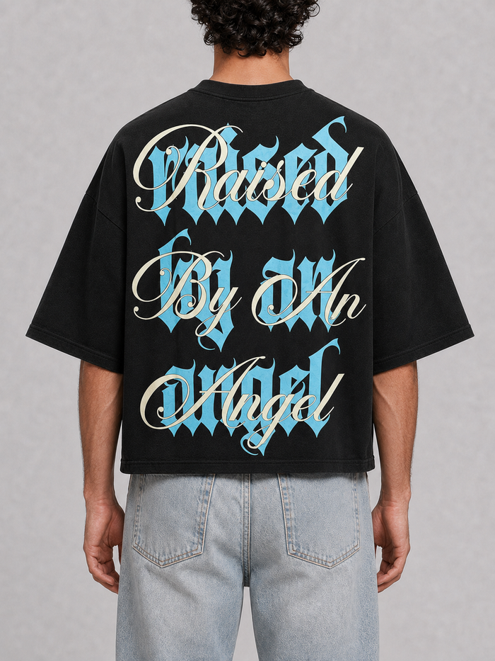 Black oversized cropped T-shirt by Silent Verse featuring the "Raised By An Angel" design, casual and stylish for everyday wear.