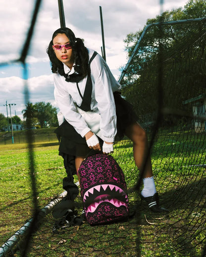 Sprayground Money Maker Shark Paper backpack featuring a vibrant shark design and bold accessories, made of durable materials.